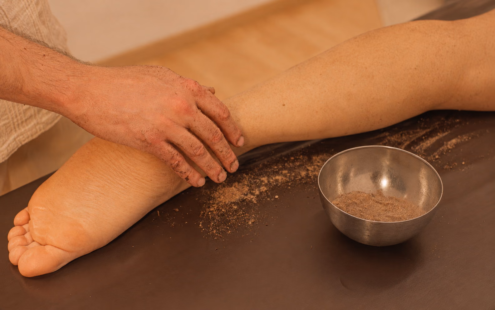 Sanfte, rhythmische Griffe entlang des Beins während einer manuellen Lymphdrainage.